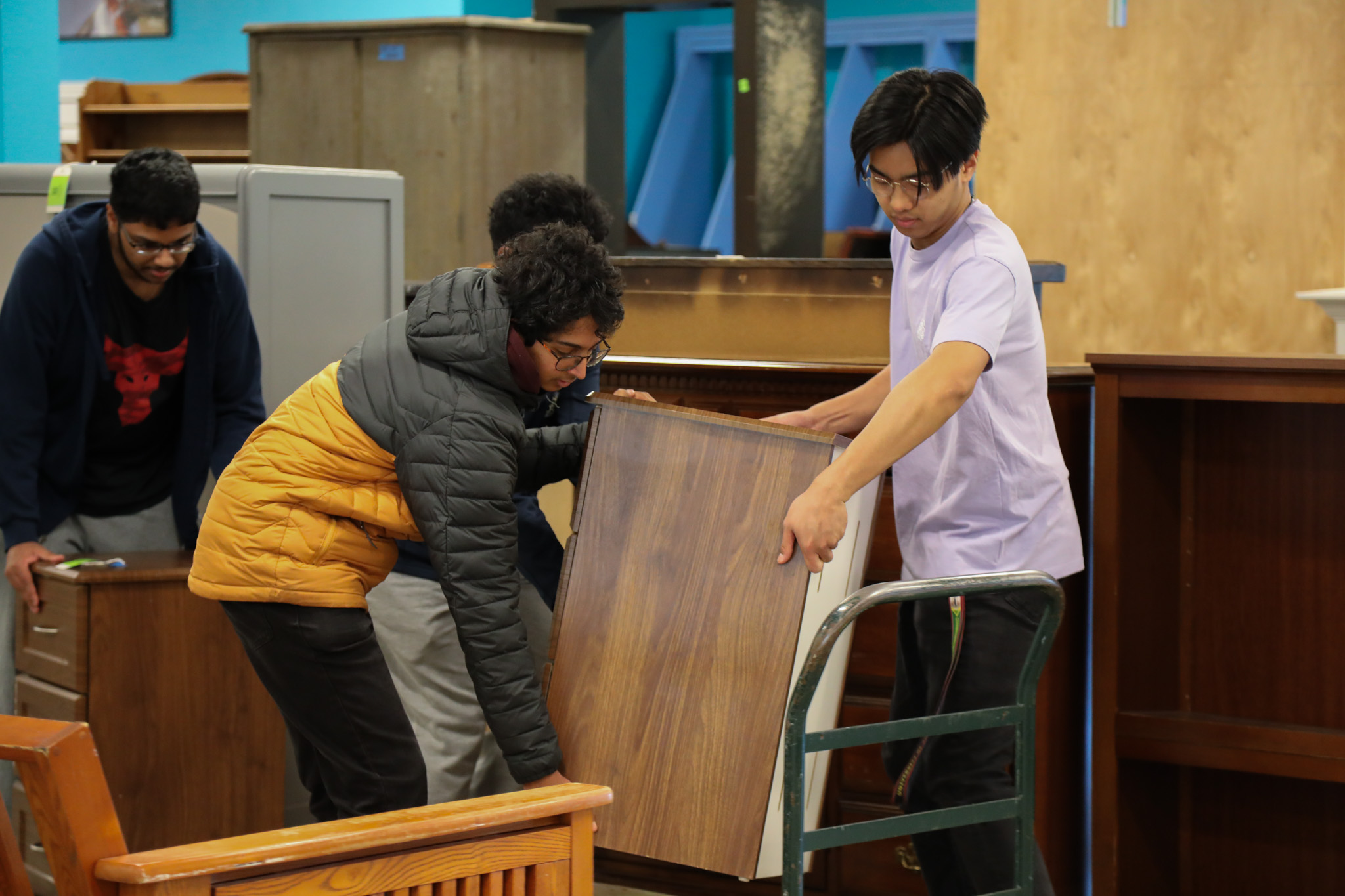 Group of student volunteers move furniture at the ReStore