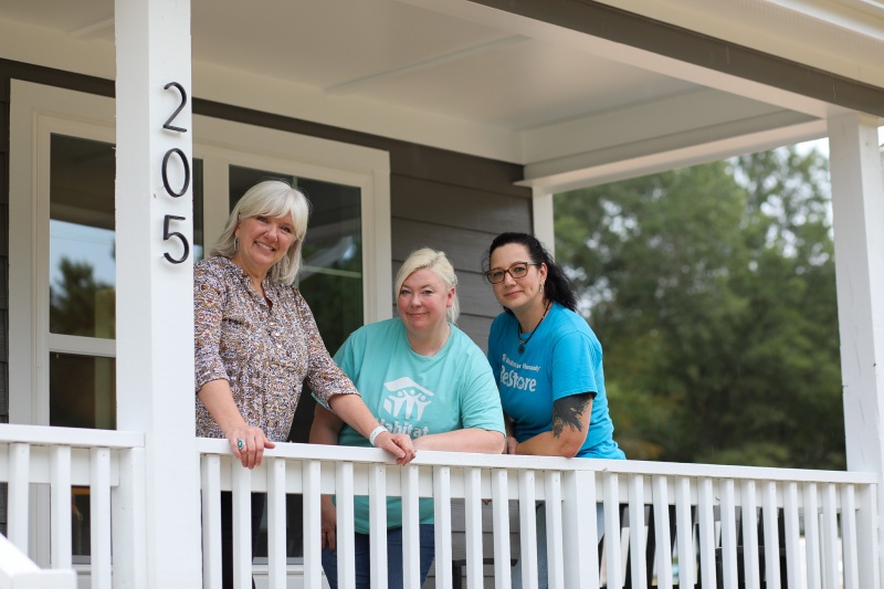 Raleigh ReStore staff pose with stager Bobbie McGrath in front of Parade of Homes Habitat House